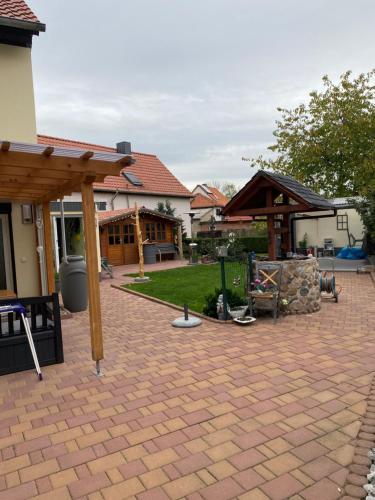 a backyard with a brick patio with a wooden pergola at Ferienwohnung im Harz in Veckenstedt