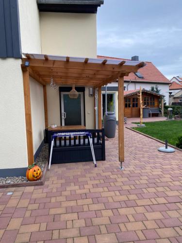 a wooden pergola with a bench on a patio at Ferienwohnung im Harz in Veckenstedt