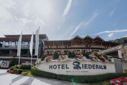 a hotel with a sign in front of a building at Hotel Riederalm in Leogang