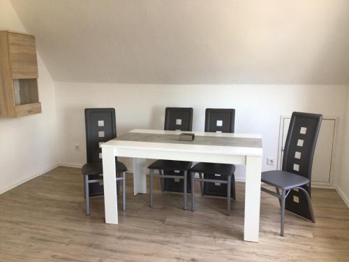 a white dining room table with four black chairs at Binge in Wetter