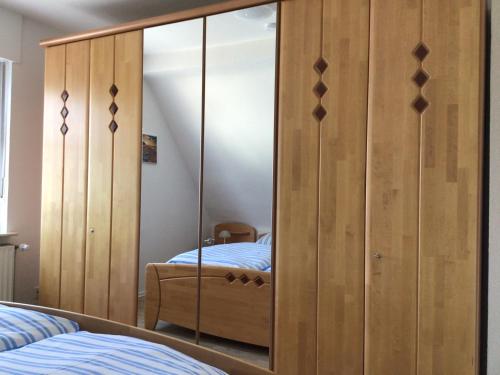 a bedroom with a large wooden cabinet with a mirror at Binge in Wetter