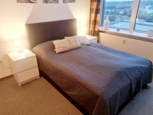 a bedroom with a bed with a blue comforter and a window at Ferienwohnung KAMINO in Schleswig