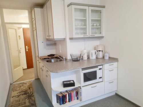 a kitchen with white cabinets and a sink at Ferienwohnung KAMINO in Schleswig