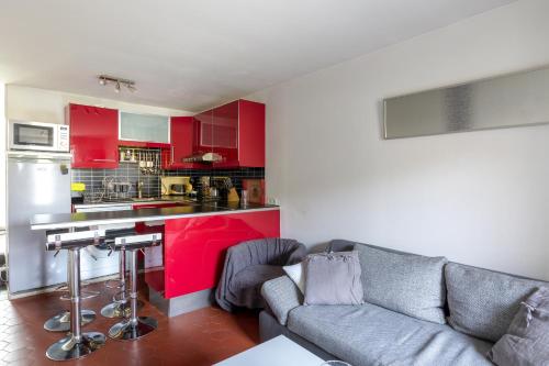 Il comprend un salon avec un canapé et une cuisine rouge. dans l'établissement Maison Mareuil, à Mareuil-lès-Meaux