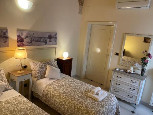 niewielka sypialnia z 2 łóżkami i lustrem w obiekcie Porta Piccola B&B w mieście Mesagne