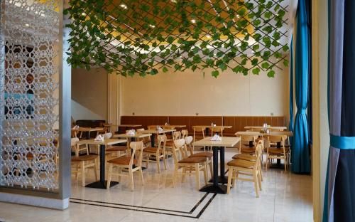 a dining room with wooden tables and chairs at G.C ROYAL HOTEL in Accra