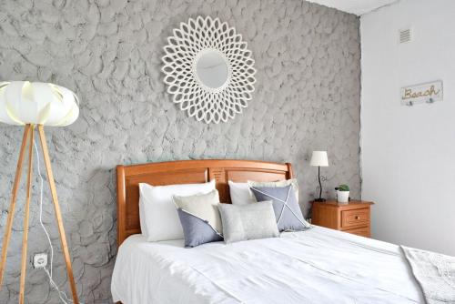 a bedroom with a bed with a mirror on the wall at Vista Mar, a Home in Madeira in Ponta do Sol