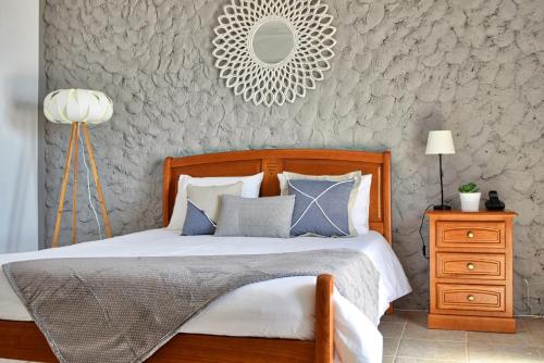 een slaapkamer met een bed en een spiegel aan de muur bij Vista Mar, a Home in Madeira in Ponta do Sol