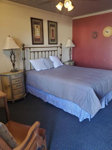 ein Schlafzimmer mit einem großen Bett und zwei Nachttischen in der Unterkunft Terrace Park Inn in Fort Morgan
