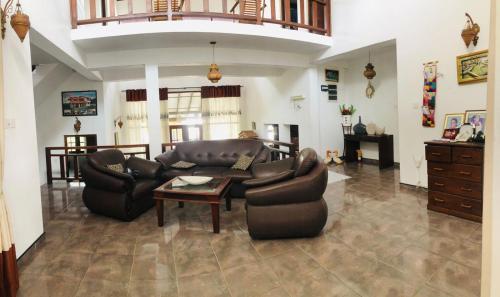a living room with a couch and chairs and a table at Villa 42 in Ahungalla