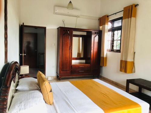 a bedroom with a large bed with a wooden headboard at Villa 42 in Ahungalla