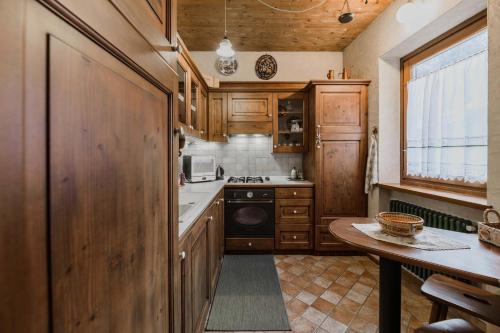 a kitchen with wooden cabinets and a table in it at Cesa Linda by AMA Val di Fassa in Campitello di Fassa