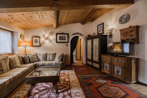 a living room with a couch and a tv at Cesa Linda by AMA Val di Fassa in Campitello di Fassa
