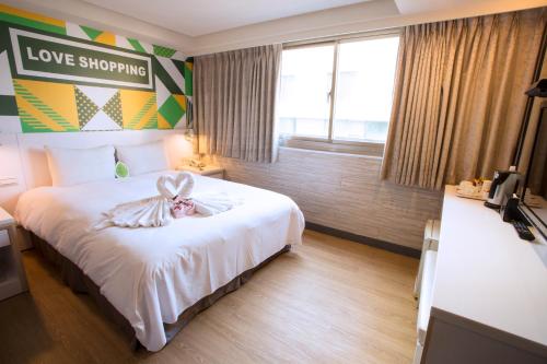 Una habitación de hotel con una cama con un conejito. en Ximen Citizen Hotel, en Taipéi
