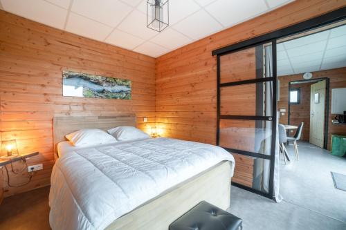 a bedroom with a bed in a room with wooden walls at Chalet d'une chambre avec jardin amenage a Saint Sylvestre in Ambazac
