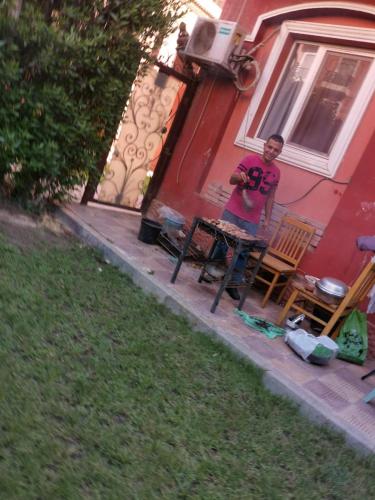a man standing in front of a red house at Hotel apartment in Sheikh Zayed City in Sheikh Zayed