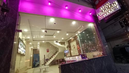 un escaparate con luces púrpuras en un edificio en Hotel Sukhman Residency en Amritsar