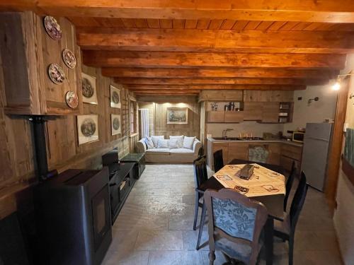 - une cuisine avec une table et un canapé dans une chambre dans l'établissement WILDHOMES Wild Wolf Lodge, à Courmayeur