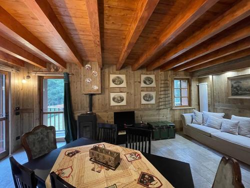 un soggiorno con un tavolo e un divano di WILDHOMES Wild Wolf Lodge a Courmayeur