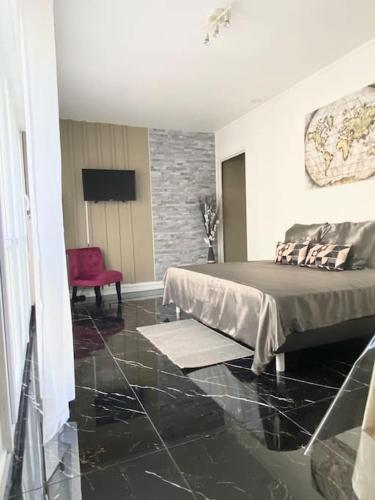 Un dormitorio con una cama y una silla roja. en Le Charmant Studio Troyen, en Troyes