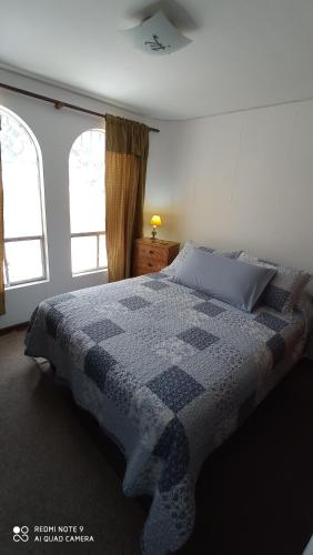 1 dormitorio con edredón azul y blanco en una cama en Depto Metro Irarrazaval Santiago, en Santiago