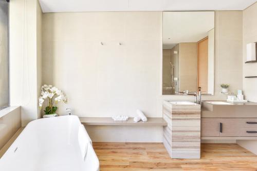 a white bathroom with a large mirror and a tub at Address Beach Residences in Dubai