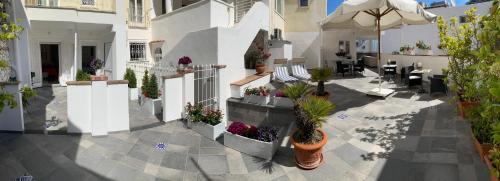 un patio esterno con piante in vaso e ombrellone di B&B Casa Silvana a Capri