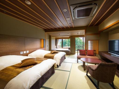 a hotel room with two beds and a flat screen tv at Kaneyamaen in Fujiyoshida