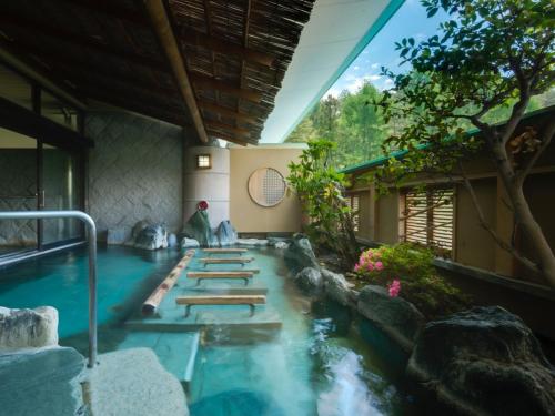 a pool in the middle of a house with a waterfall at Kaneyamaen in Fujiyoshida