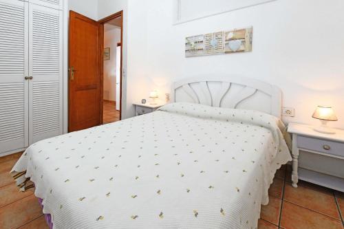 una camera con un letto bianco e due comodini di Casa La Caleta a Los Llanos de Aridane