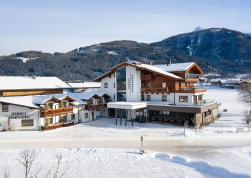 een resort in de sneeuw met een berg op de achtergrond bij Harmls Aparthotel in Flachau