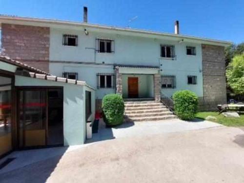 un gran edificio blanco con una puerta roja en La Vista de Gredos III, en Navarredonda de Gredos