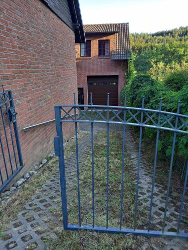 an iron gate in front of a brick building at Appartement Spatzennest in Mossautal
