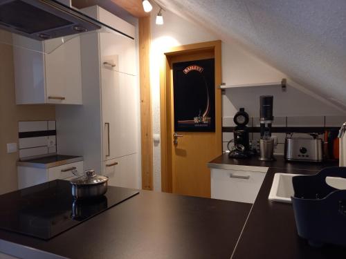 a kitchen with a black counter top and a door at Appartement Spatzennest in Mossautal