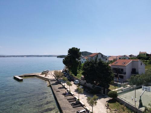 a view of a beach with cars parked next to the water at Beachfront apartments Calm Sea in Preko