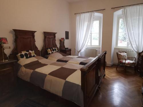 um quarto com 2 camas e 2 janelas em Charming apartment in a 19th century villa em Trieste