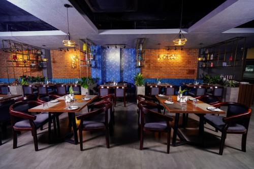 a dining room with wooden tables and chairs at Lantern Apart Hotel in Perintalmanna