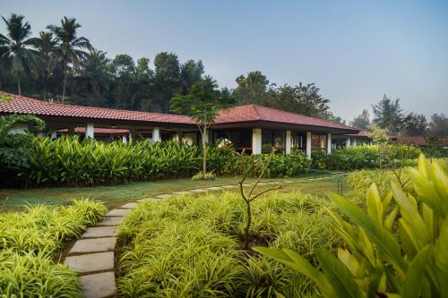 a house with a pathway in front of a garden at Denissons Beach Resort, formerly Gamyam Retreat in Kumta