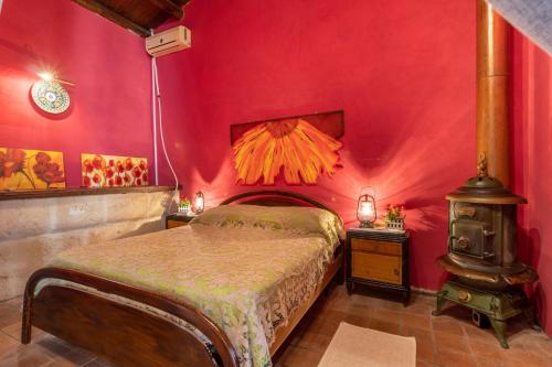 - une chambre avec un lit et un mur rouge dans l'établissement Casa Vacanze Villa Giada Jacuzzi, à Raguse