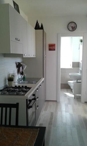 a kitchen with a sink and a stove top oven at Appartamento Valentina: relax e natura in Sirolo