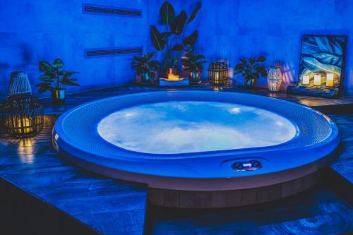 a jacuzzi tub in a room with plants at TatryTop Apartamenty Alpejski SPA in Kościelisko