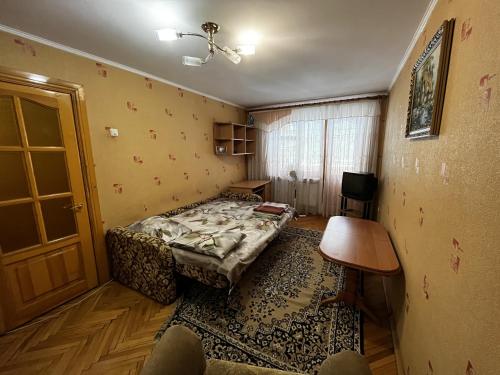um quarto com uma cama, uma mesa e uma porta em Апартаменты рядом с парком центр em Vinnytsya