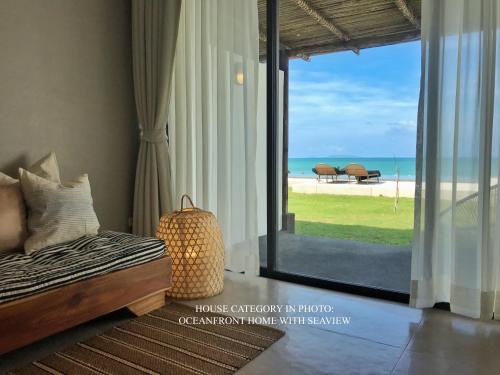 a bedroom with a bed and a view of the beach at Silan Residence, Koh Phangan - An authentic village experience in Chaloklum