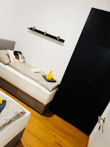a bedroom with two twin beds and a black door at Leon 3 wunderschönes neues Apartment in Linz
