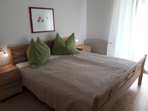 a bedroom with a large bed with green pillows at Ferienwohnungen Weissenbacher in Mitterbach