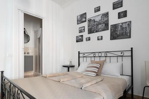 a bed in a white bedroom with pictures on the wall at Zaira b&b in Rome