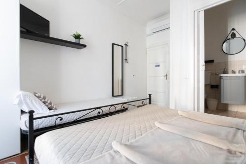 a white bedroom with a bed and a mirror at Zaira b&b in Rome