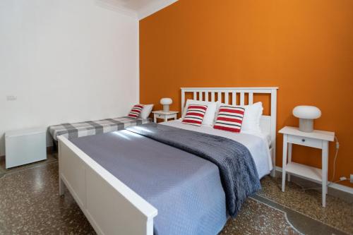 a bedroom with a large bed with orange walls at Zaira b&b in Rome