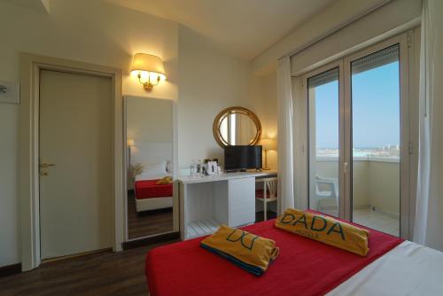 a bedroom with a bed with a red blanket at Hotel Imperial Beach - Dada Hotels in Rimini