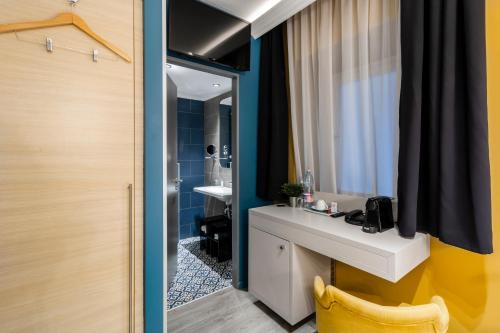 W łazience znajduje się biała umywalka i lustro. w obiekcie Alta Moda Fashion Hotel w Budapeszcie